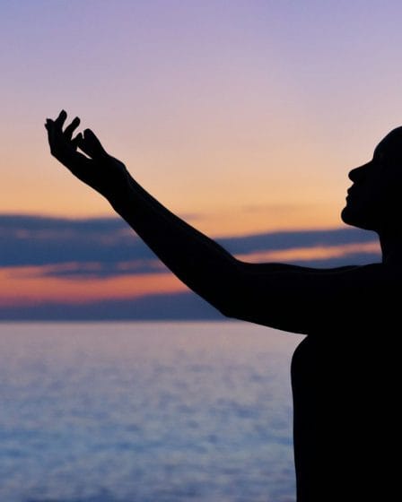 silhouette of woman raising her right hand